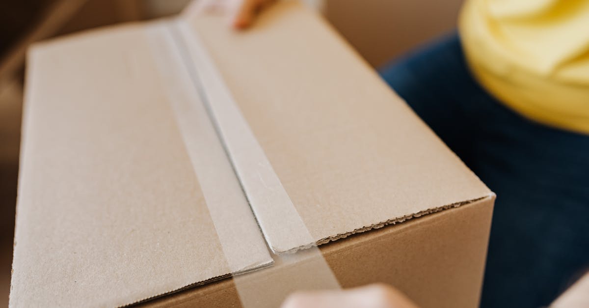 How close must my friends be in order to trade in Pokémon Home? - Crop man sealing cardboard box with tape
