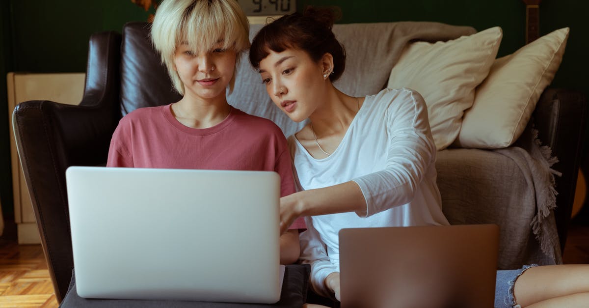 How close must my friends be in order to trade in Pokémon Home? - Young Asian female friends using laptops while working on collaborative project on floor in room