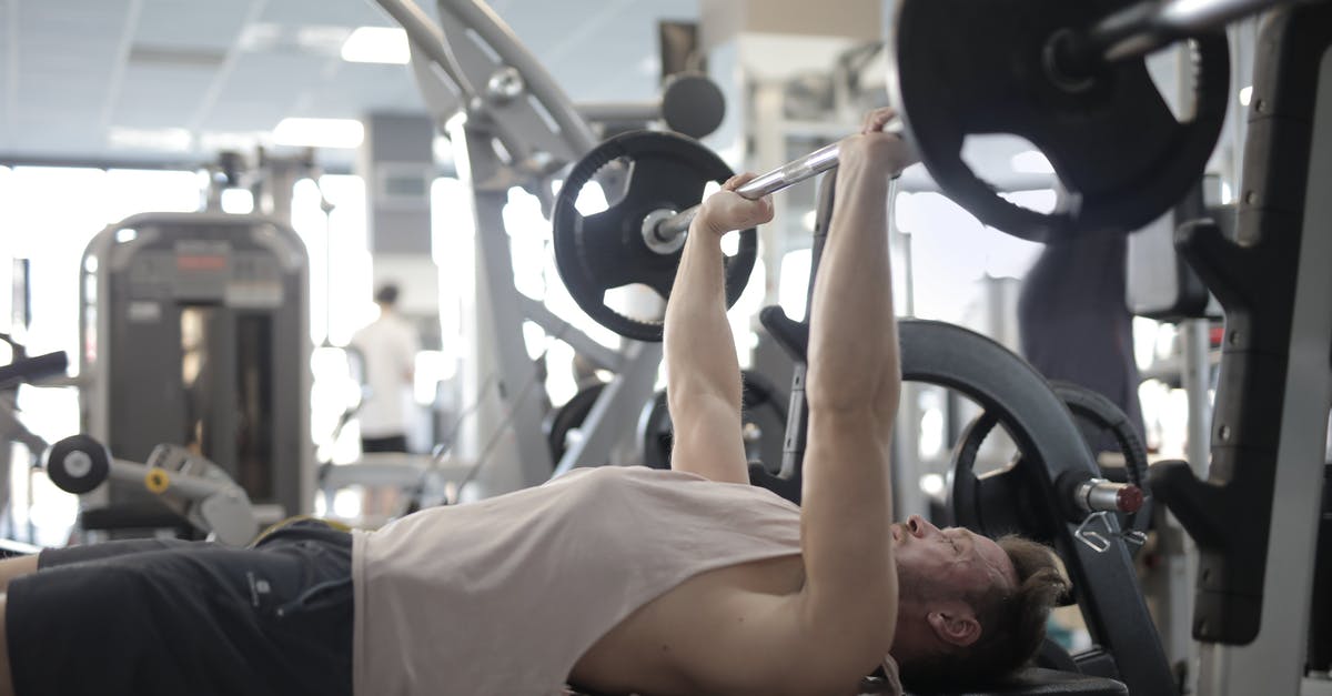 How do I add a scoreboard listing the health of other players when I press TAB? - Muscular sportsman training with heavy barbell during weightlifting workout in modern gym