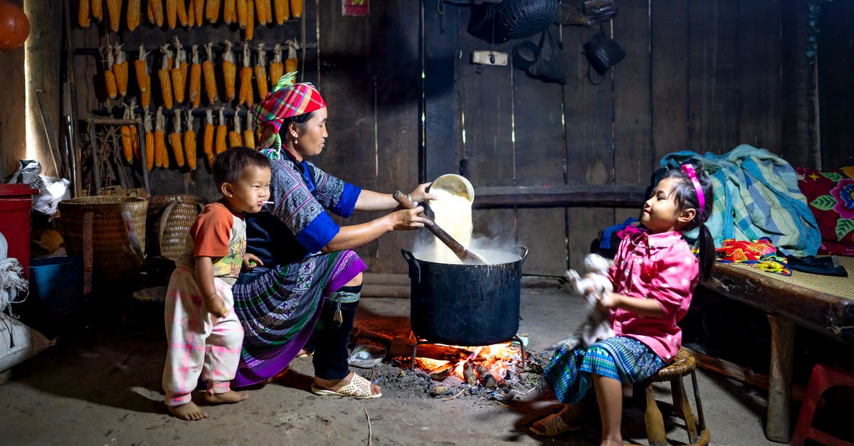 How do I align the version numbers of my Epic and Steam versions so I can play together? - Ethnic mother pouring rice into pot on fire against daughter with cat and barefoot baby eating lollipop at home