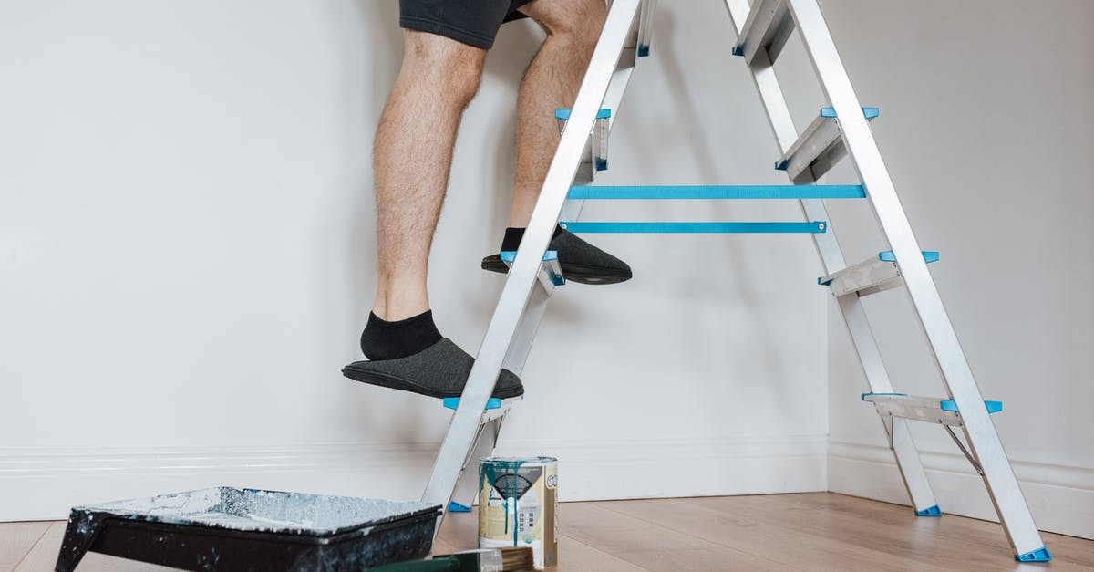 How do I climb stairs? - Side view of crop unrecognizable painter in slippers standing on stepladder while renovating room with brush in soft daylight How do I climb stairs? - Side view of crop unrecognizable painter in slippers standing on stepladder while renovating room with brush in soft daylight