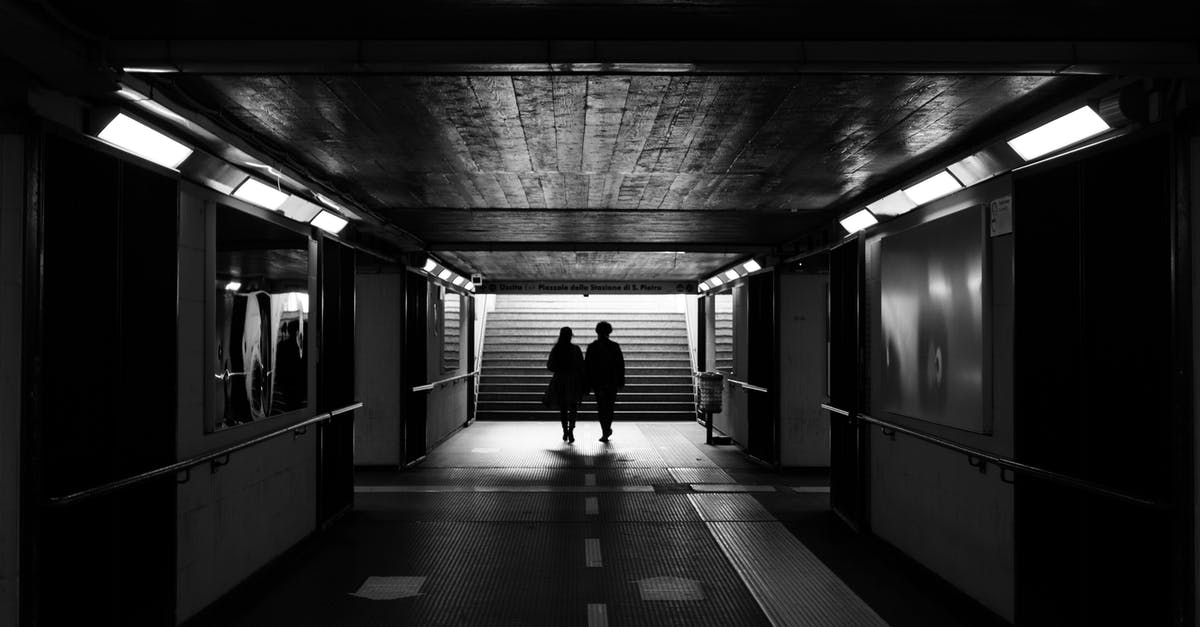 How do I climb stairs? - Back view black and white of unrecognizable passengers walking to stairs in subway station How do I climb stairs? - Back view black and white of unrecognizable passengers walking to stairs in subway station
