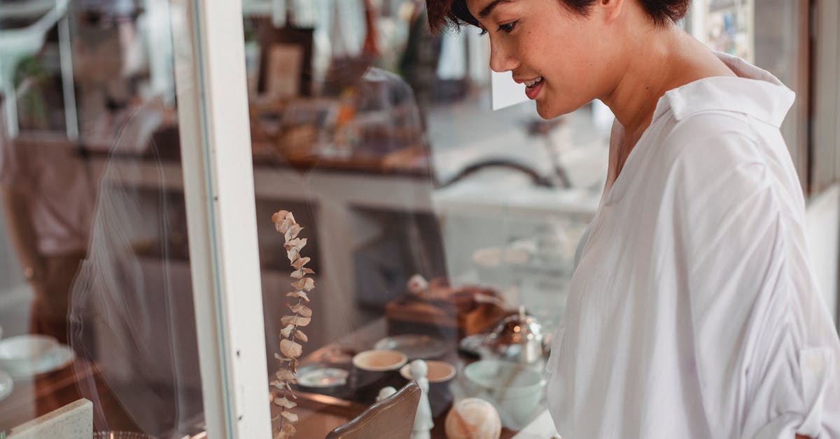 How do I collect loot stored in my town hall? - Side view of crop young smiling ethnic female watching assortment of store through glass wall in city How do I collect loot stored in my town hall? - Side view of crop young smiling ethnic female watching assortment of store through glass wall in city
