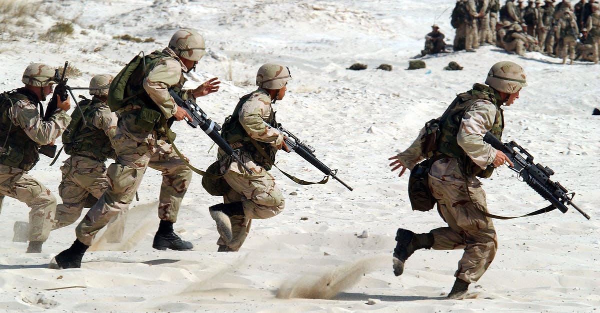 How do I compare weapons in-game? - 5 Soldiers Holding Rifle Running on White Sand during Daytime