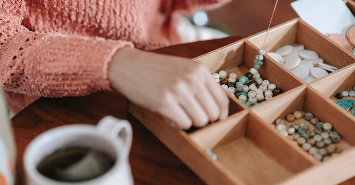 How do I create a '4 or 5 Alembic-Size' 'Label Free' essentia distributor? - Faceless woman making handmade accessory sitting at table How do I create a '4 or 5 Alembic-Size' 'Label Free' essentia distributor? - Faceless woman making handmade accessory sitting at table