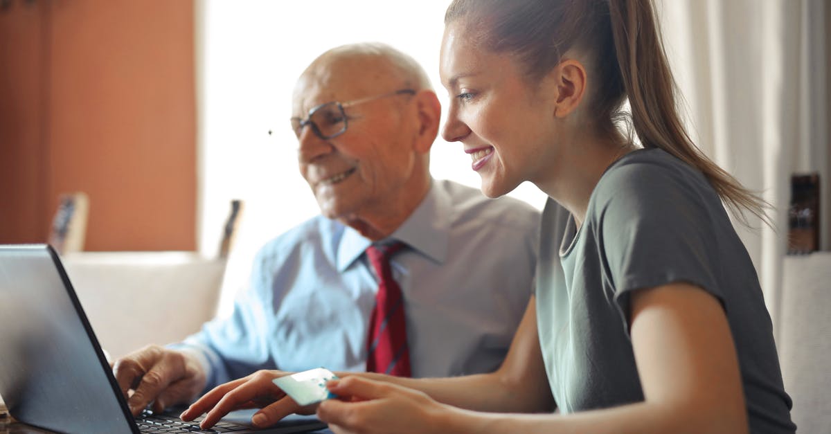 How do I delete a custom room? - Young woman in casual clothes helping senior man in formal shirt with paying credit card in Internet using laptop while sitting at table