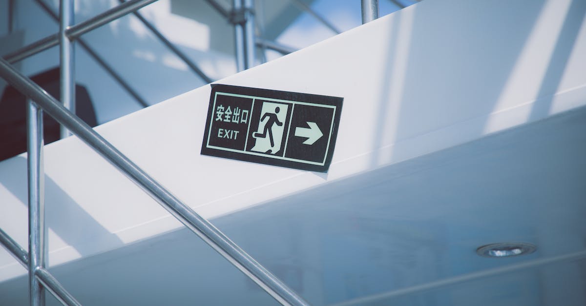 How do I design an efficient exit from a large one-way road? - From below of rectangular signboard with EXIT title and symbol of running figure near stairs with handrail in modern house How do I design an efficient exit from a large one-way road? - From below of rectangular signboard with EXIT title and symbol of running figure near stairs with handrail in modern house