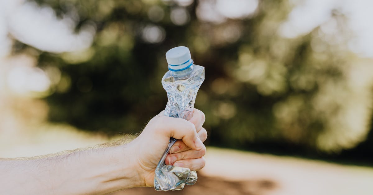 How do I dispose of a corpse? - Crop man crushing plastic bottle