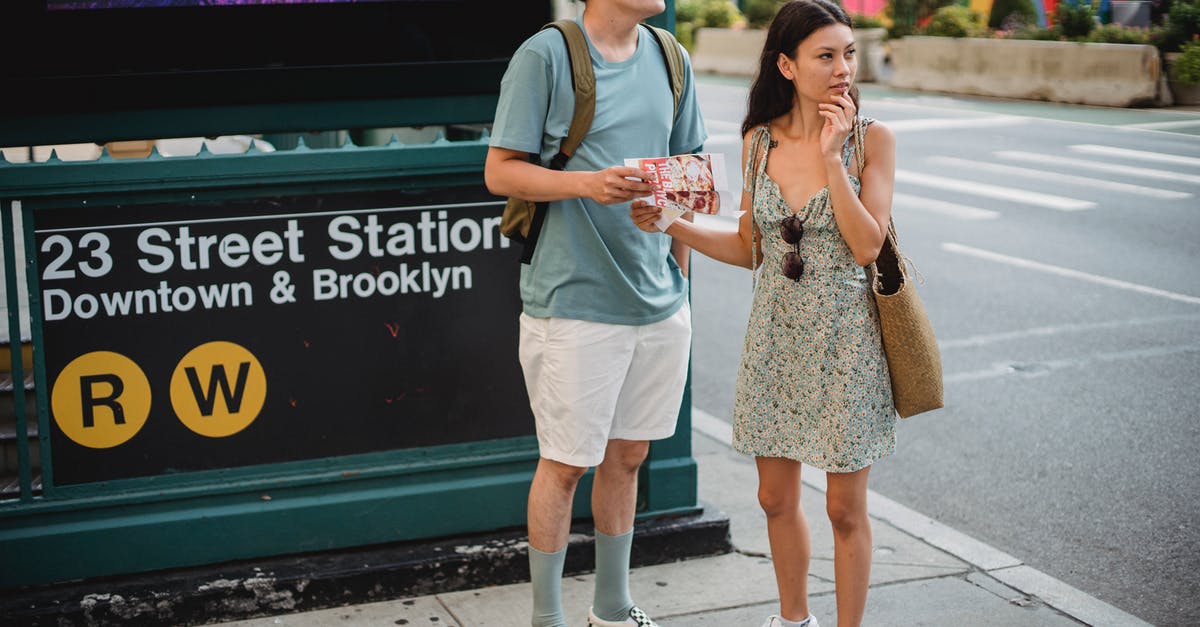 How do I find bastions? - Full body of diverse couple standing with map while trying to find direction in city center during trip