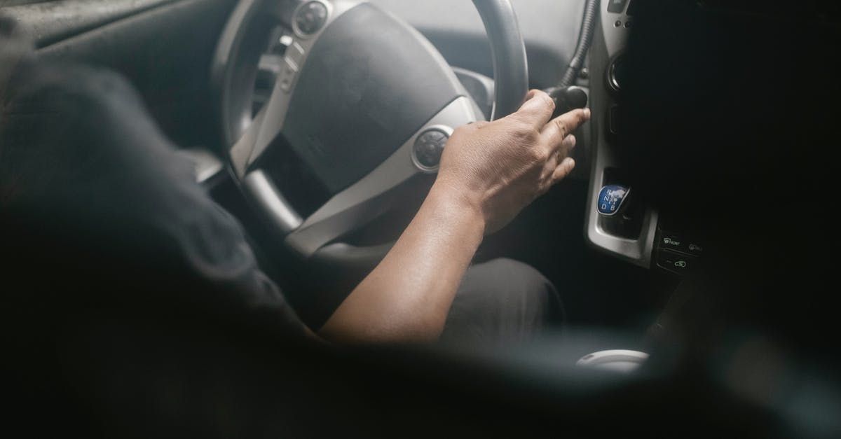 How do I find the worm-riding manual pages? - High angle of crop unrecognizable male driving modern car on street on sunny day