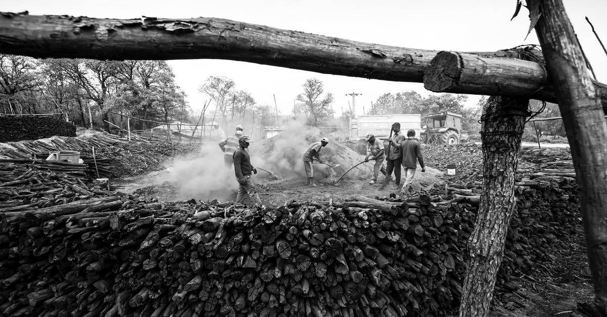 How do I gather resources? - Black and white group of male workers with shovels around dusty pile during wood preparation