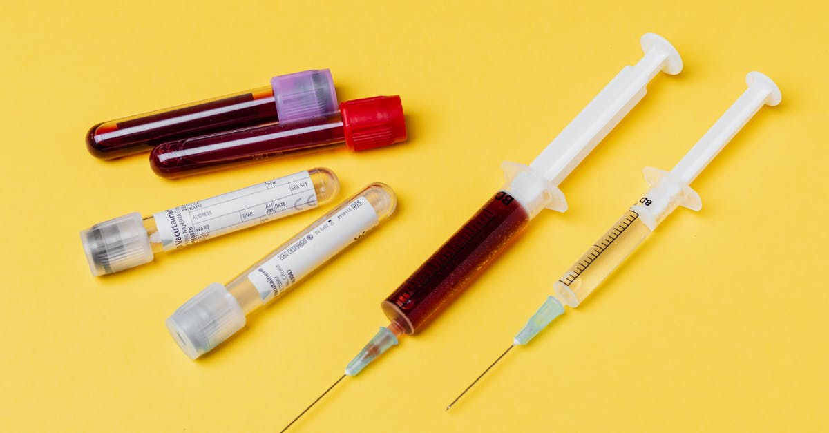 How do I get a blood sample from the Manbat? - From above of medical syringe with medication near injector with blood sample arranged with filled clinical test tubes placed on yellow background
