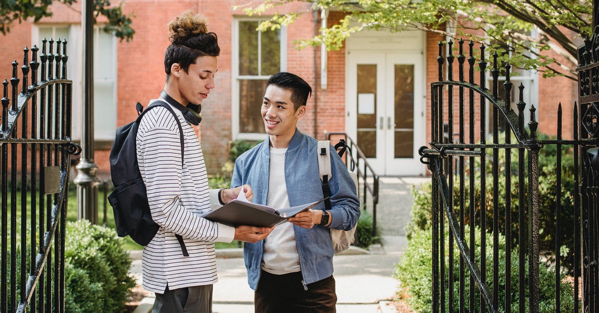 How do I get a .minecraft folder [closed] - Cheerful diverse male classmates with paper document in folder standing close and discussing task at university entrance