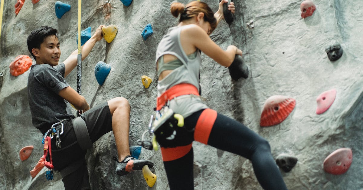How do I get Ascendant Shards & Ascendant Energy? - Low angle of young Asian male and female friends in sportswear and protective harness practicing bouldering together in climbing gym