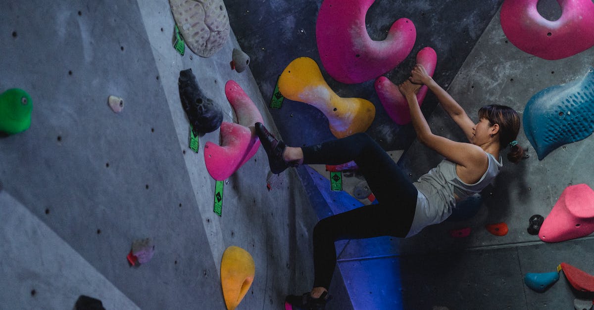How do I get Ascendant Shards & Ascendant Energy? - Side view full body of Asian female alpinist during workout on climbing wall in bouldering gym