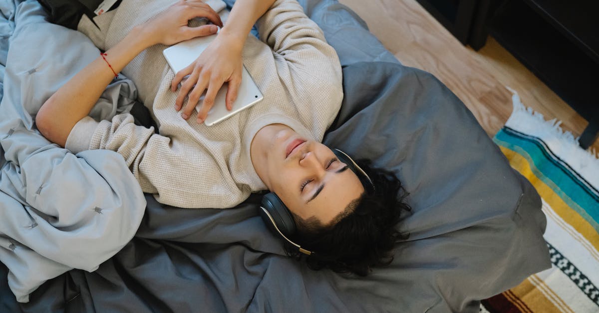 How do I get audio from the GamePad headphone jack? - From above young Hispanic guy with tablet listening to music with closed eyes while chilling on comfortable bed at home How do I get audio from the GamePad headphone jack? - From above young Hispanic guy with tablet listening to music with closed eyes while chilling on comfortable bed at home