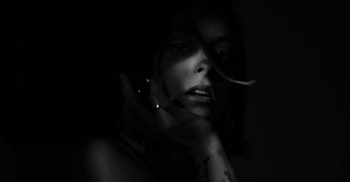 How do I get charms in a dark room? - Unrecognizable woman with sensitive lips on black background at night How do I get charms in a dark room? - Unrecognizable woman with sensitive lips on black background at night
