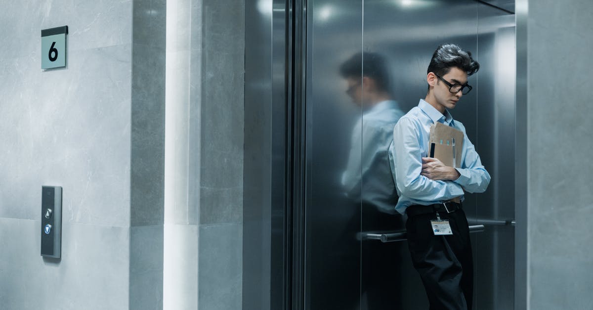 How do I get down the elevator shaft? - A Man in Blue Long Sleeves Looking Down while Embracing Brown Envelopes How do I get down the elevator shaft? - A Man in Blue Long Sleeves Looking Down while Embracing Brown Envelopes