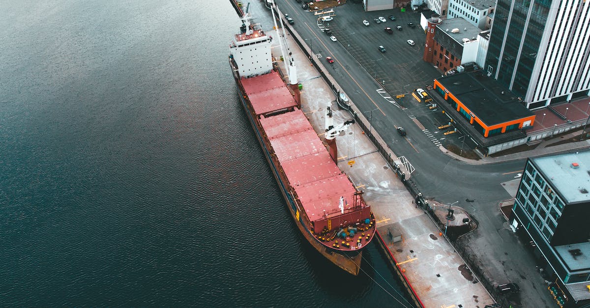 How do I get freight going from one city to another? - Drone view of modern dock with industrial ship moored in rippling water in daytime How do I get freight going from one city to another? - Drone view of modern dock with industrial ship moored in rippling water in daytime