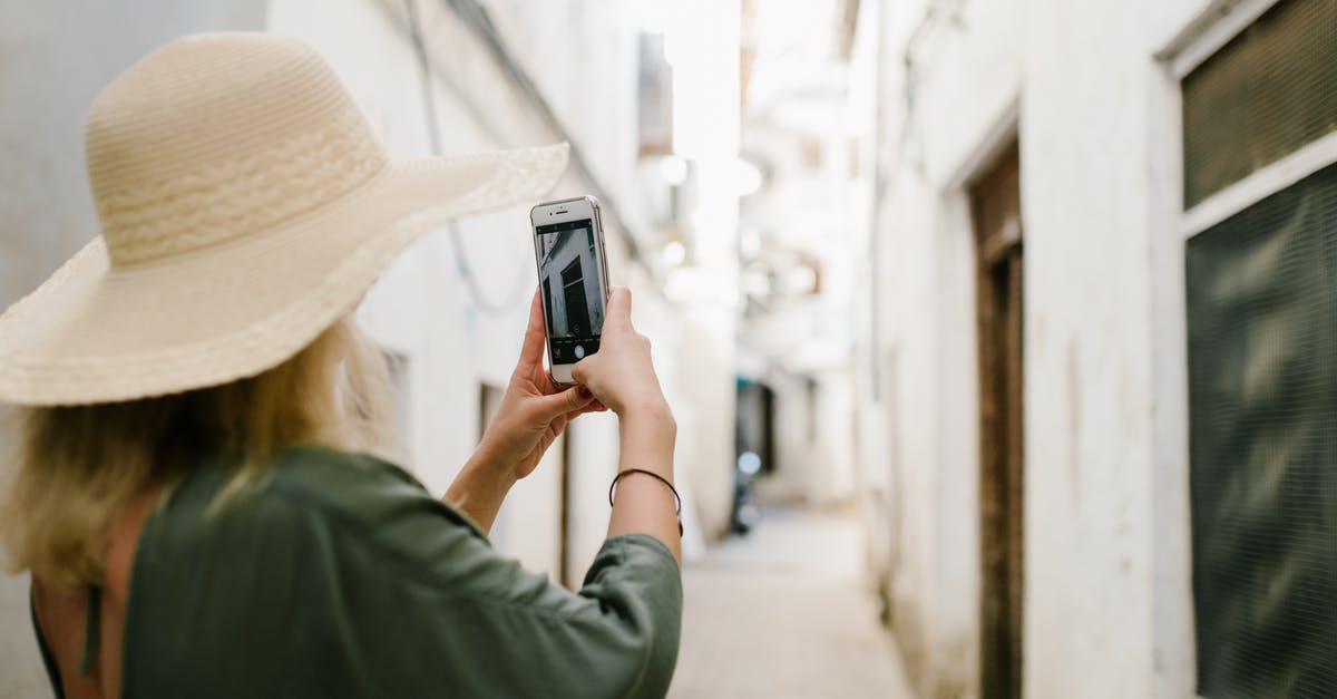How do I get my old account back after my phone got stolen? - Woman taking photo of building in alley How do I get my old account back after my phone got stolen? - Woman taking photo of building in alley