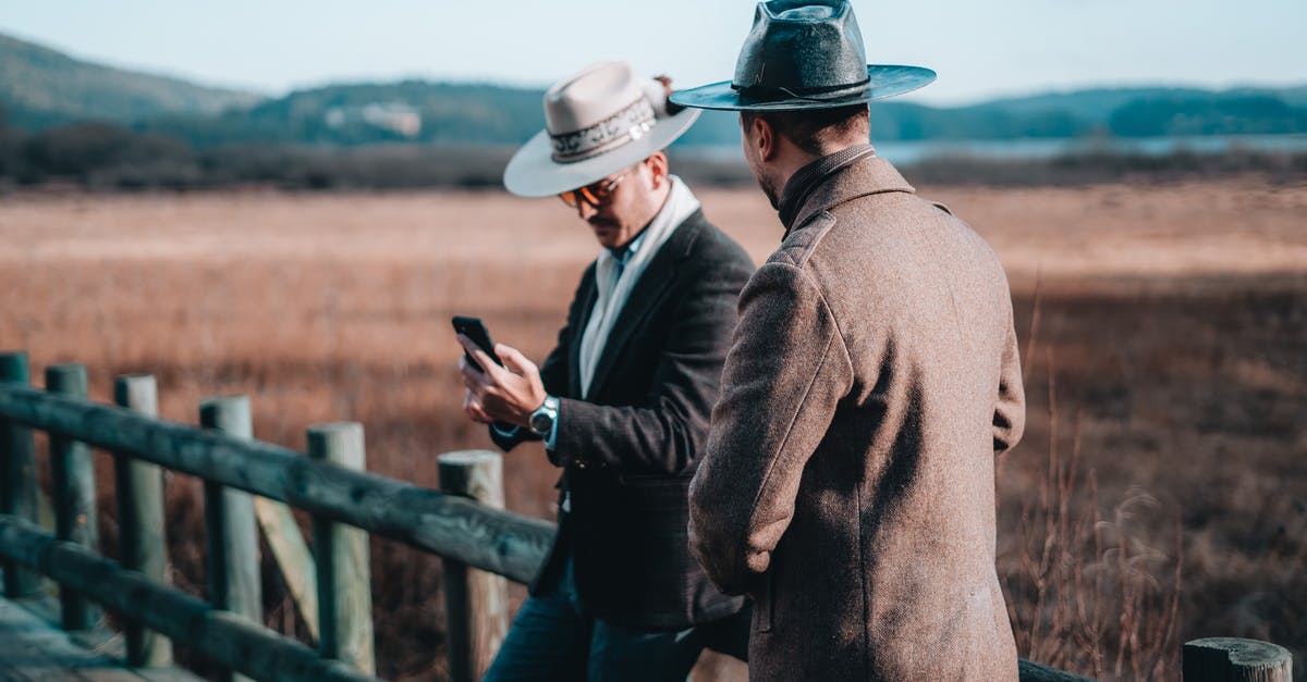 How do I get my village on my phone - Males in cowboy hats near wooden railing How do I get my village on my phone - Males in cowboy hats near wooden railing