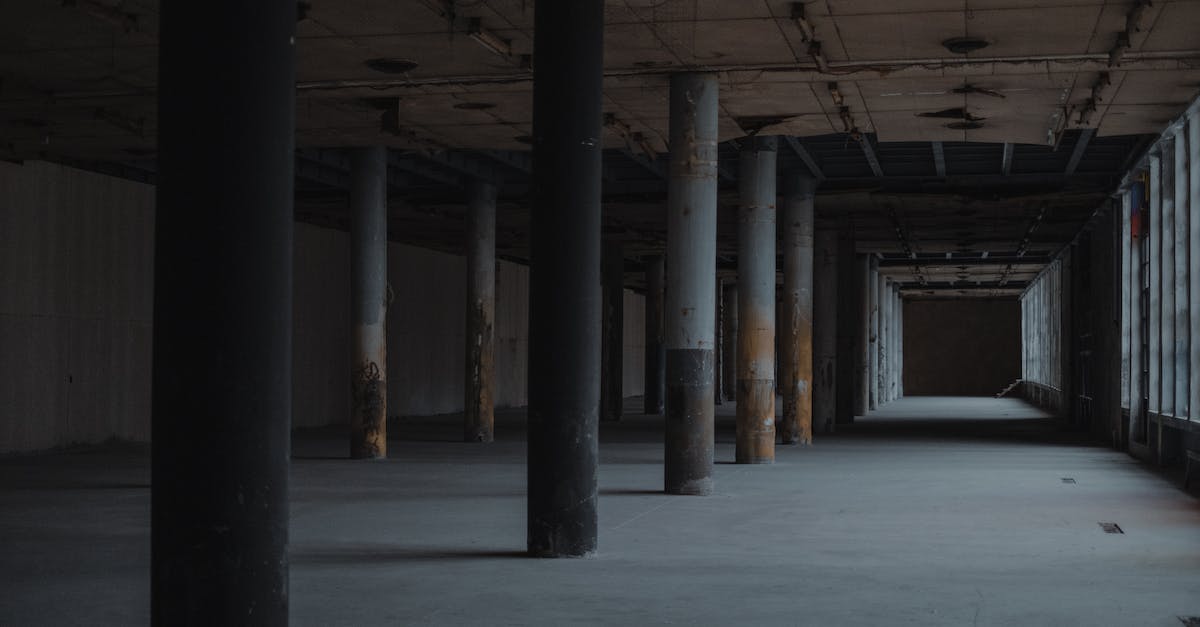 How do I get out of the spiked ceiling room? - Perspective view of empty shabby spacious hall with columns in front of windows and exit in far side in semidarkness How do I get out of the spiked ceiling room? - Perspective view of empty shabby spacious hall with columns in front of windows and exit in far side in semidarkness