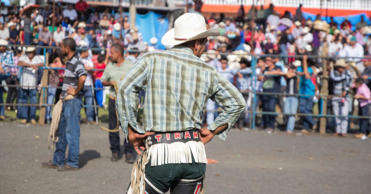 How do I get rodeo kills? - Man in Blue and White Plaid Dress Shirt and White Cowboy Hat Walking on Street during