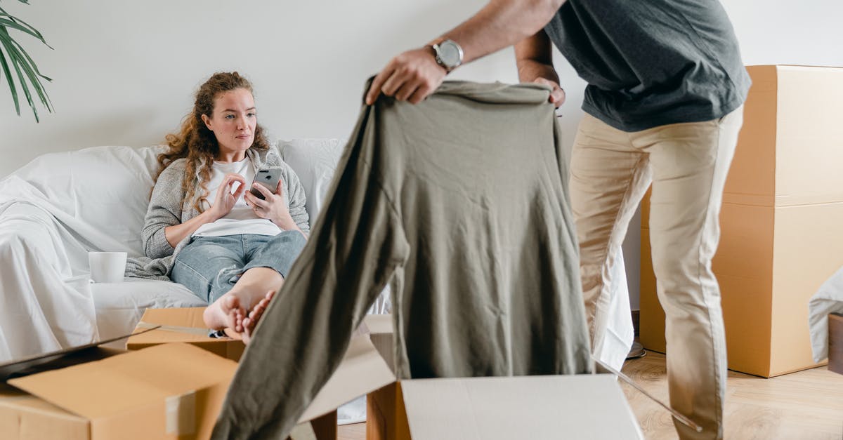 How do I get the new pets, Orby and Asmody? - Crop anonymous male in watch getting polo neck out of cardboard box while standing near pensive barefoot girlfriend sitting with crossed legs on comfortable couch after moving into new flat