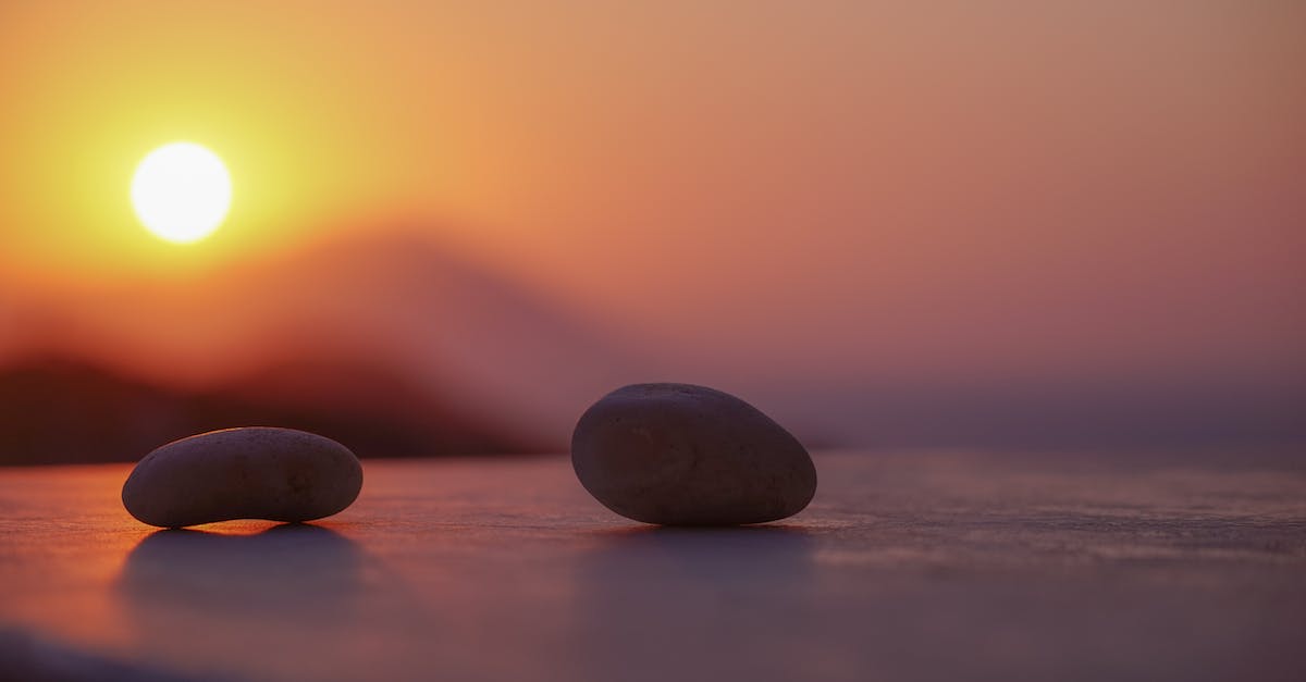How do I get the second Sun Stone in level 2-4? - Ground level of stones on sandy shore near ocean behind mountains under bright sky with shining sun in twilight