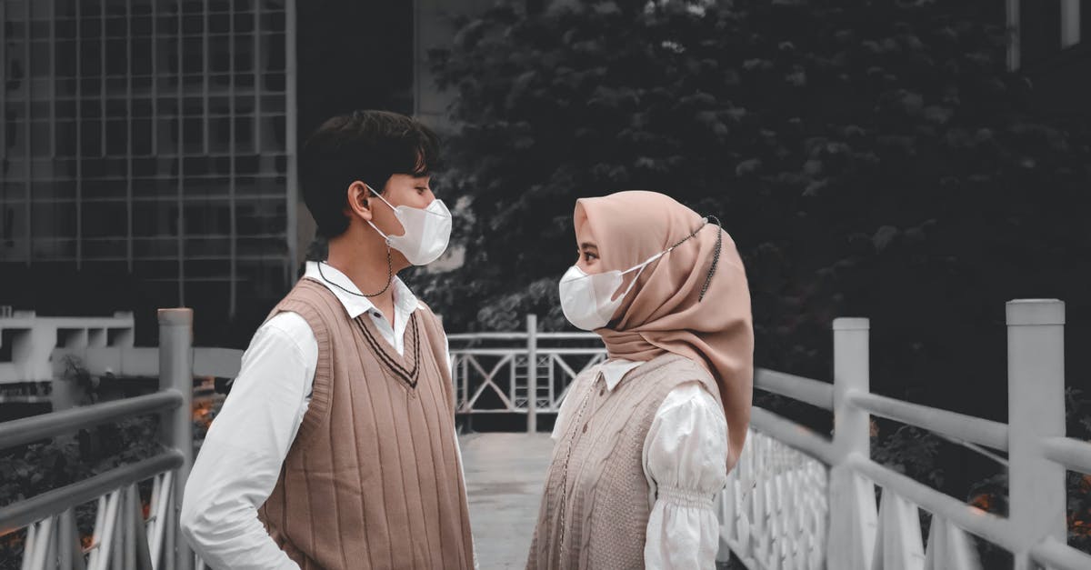 How do I get to the other side of this bridge? - A Couple Wearing Face Mask while Looking at Each Other