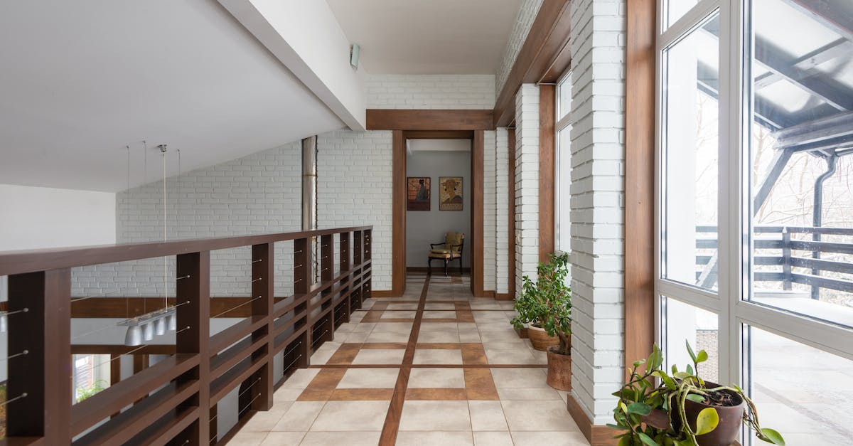 How do I get to the second floor of the Lecture Building? - Long corridor with wooden railing and potted green flowers placed near bid windows located on second floor of contemporary house How do I get to the second floor of the Lecture Building? - Long corridor with wooden railing and potted green flowers placed near bid windows located on second floor of contemporary house