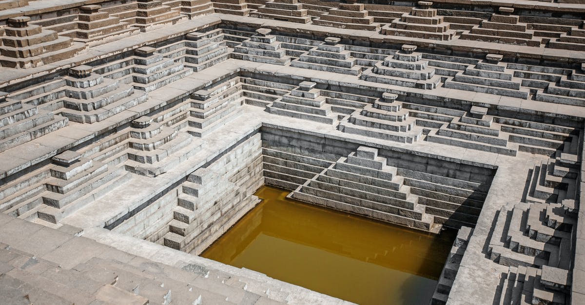 How do I get water from a well into my waterskin? - From above or stone rows of stairs of stepped well with dirty water in Hampi India