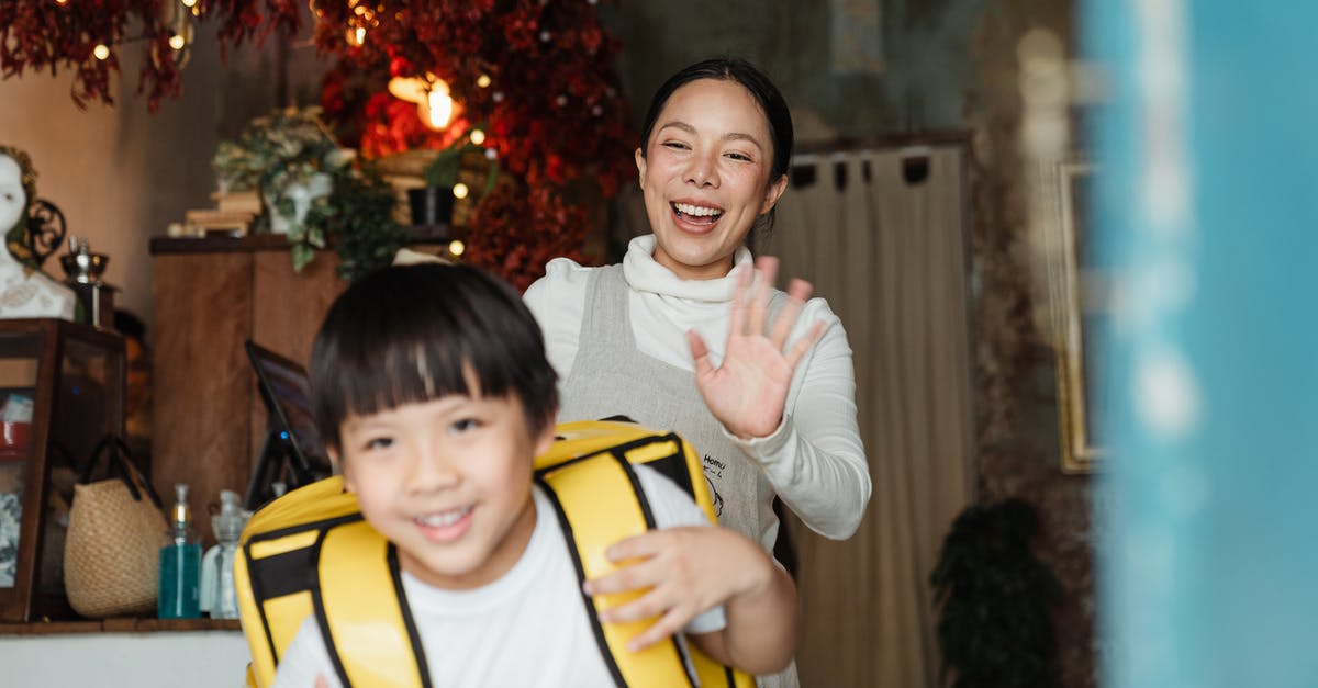 How do I help my staff be happy? - Cheerful ethnic mother saying goodbye to son with food backpack