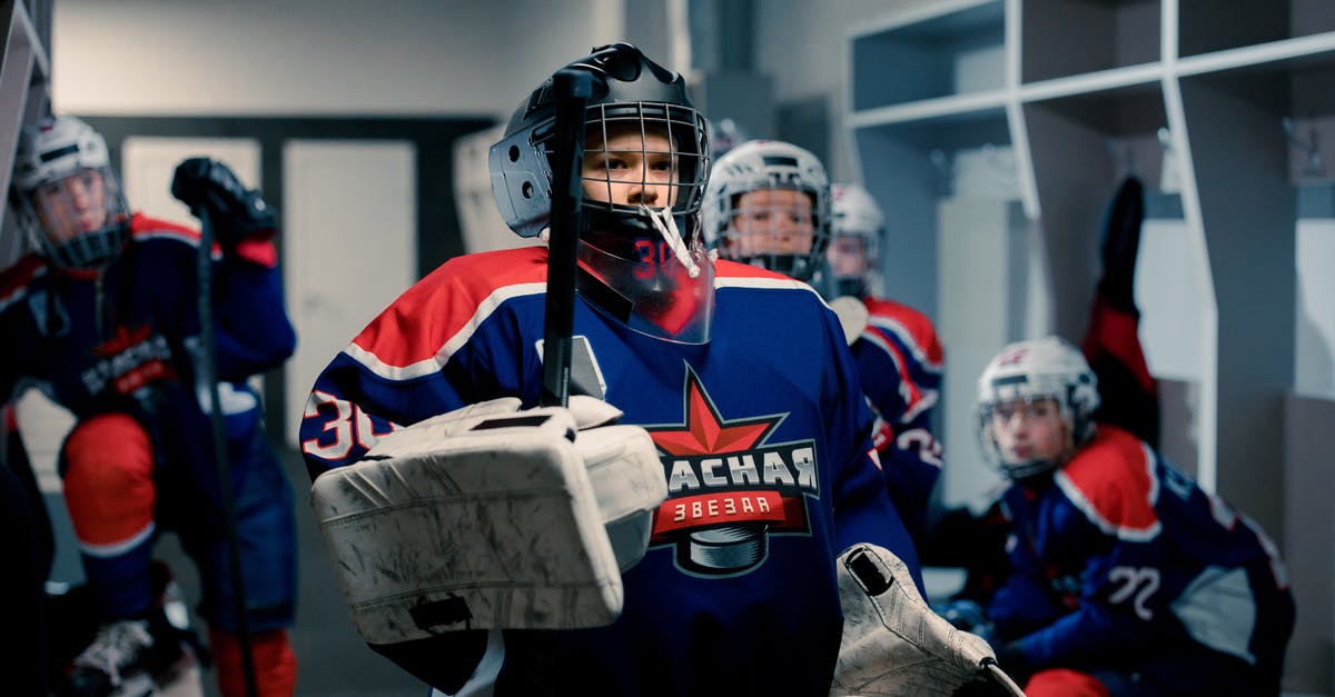 How do I increase my Team Rank and what does it get me? - A Boy in Hockey Uniform Standing in the Locker Room