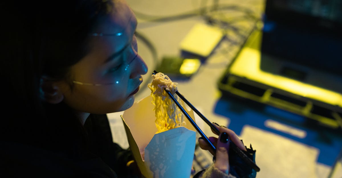 How do I keep my animals from eating my people food? - A High Angle Shot of a Woman Holding a Chopsticks with Noodles