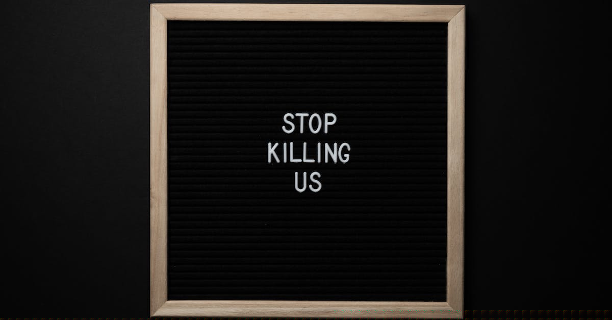 How do I kill the updated Developer? - Top view of slogan Stop Killing Us on surface of square blackboard on black background