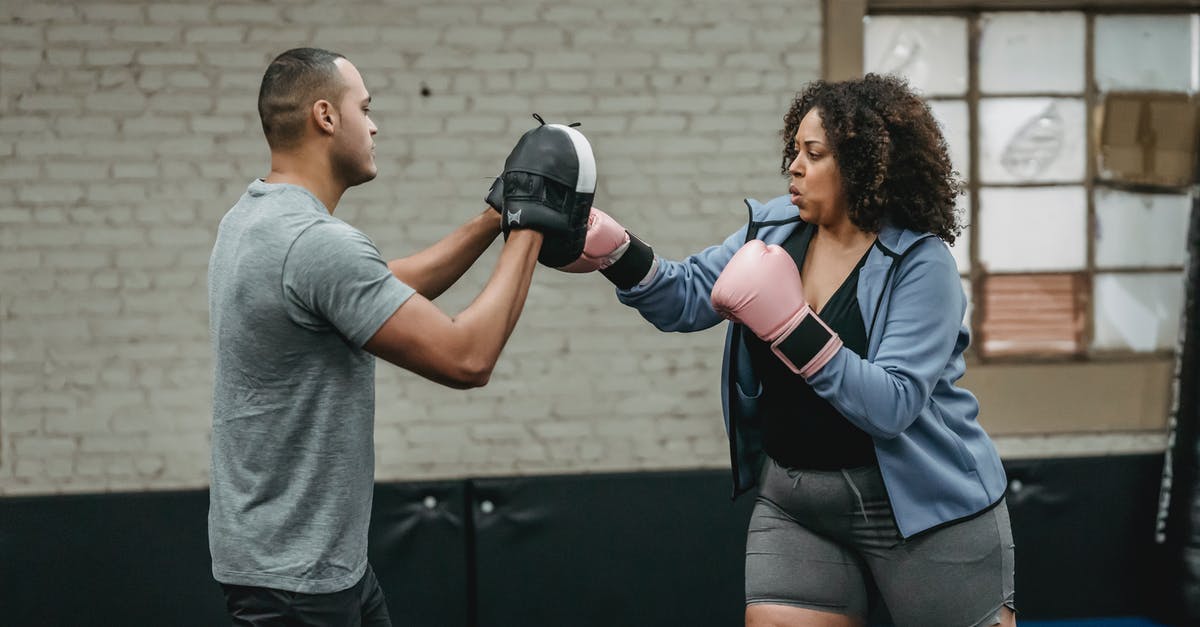 How do I knock over the pins on level W3-4 strike lake? - Ethnic instructor working out with plump black boxer in gymnasium