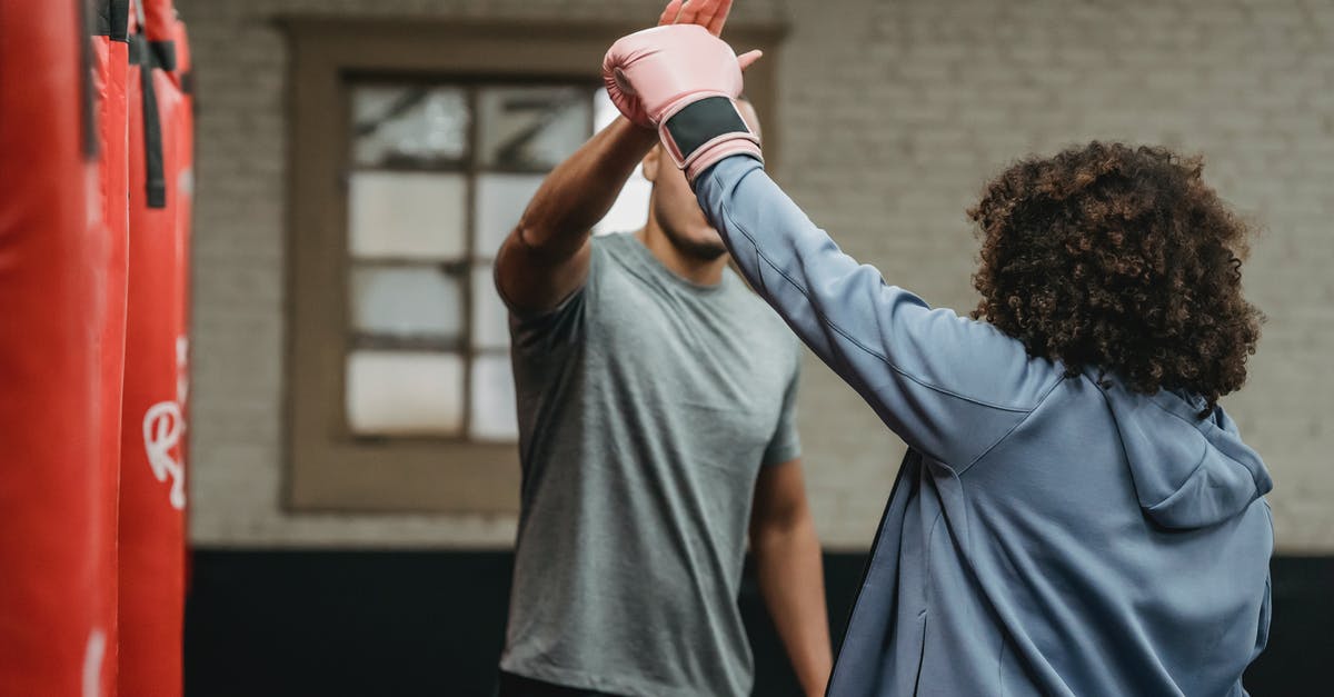 How do I knock over the pins on level W3-4 strike lake? - Anonymous male trainer explaining punching technique to female boxer in glove during training in gymnasium