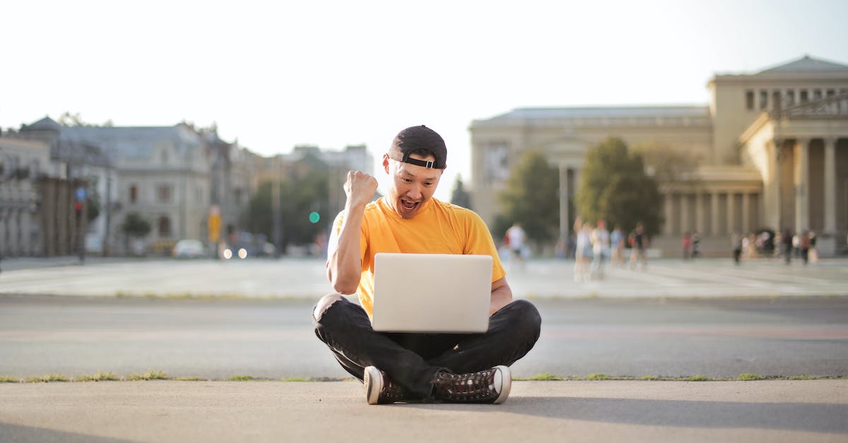 How do I know if a city is connected by wireless? - Man in White T-shirt and Black Pants Sitting on the Road Using Laptop Computer How do I know if a city is connected by wireless? - Man in White T-shirt and Black Pants Sitting on the Road Using Laptop Computer
