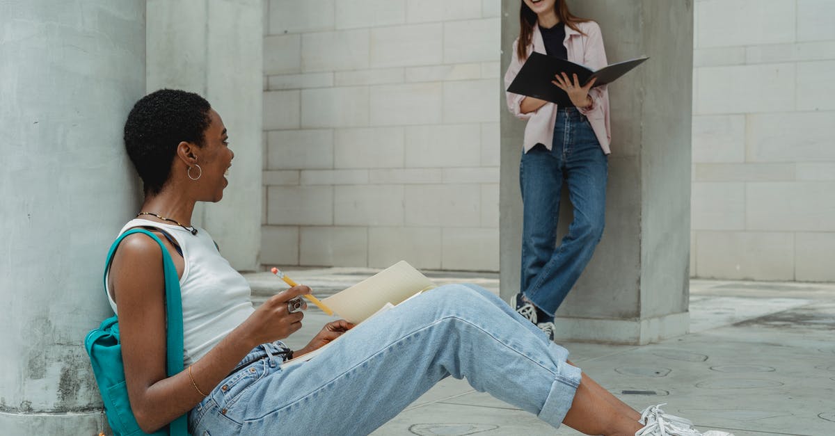 How do I know what research I have already done? - Cheerful young multiracial female students in casual clothes laughing while taking notes and reading papers making project together