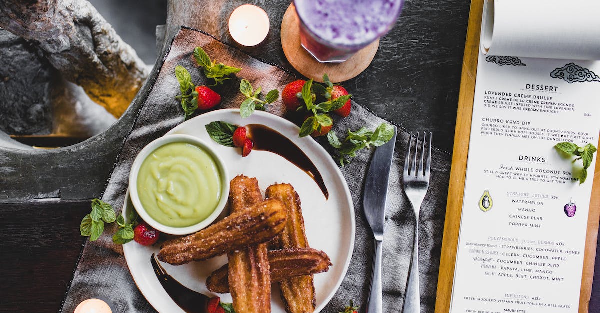 How do I leave the Knife & Candle? - From above of delicious Spanish churros with green dip sauce garnished with fresh strawberries and melted chocolate near glass of blueberry milkshake and menu in restaurant