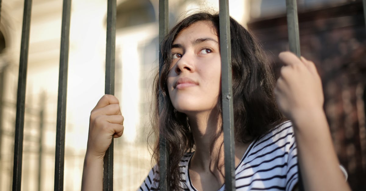 How do I limit how far from a stockpile a dwarf is allowed to go to fetch items? - Sad isolated young woman looking away through fence with hope