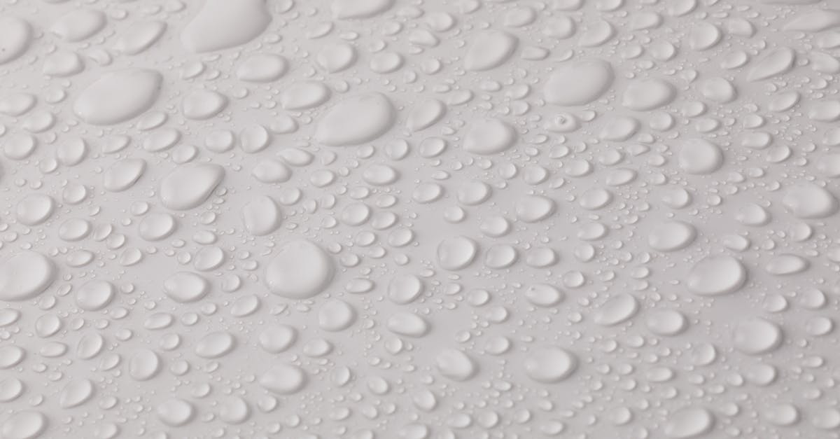 How do I lower the water even more? - Closeup top view of plain wet abstract surface with small dripped water drops of different shapes placed on white background How do I lower the water even more? - Closeup top view of plain wet abstract surface with small dripped water drops of different shapes placed on white background