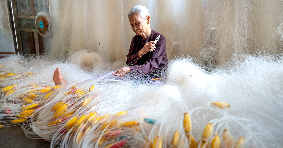 How do I make floating words? - Senior Asian woman making fishing net at home How do I make floating words? - Senior Asian woman making fishing net at home