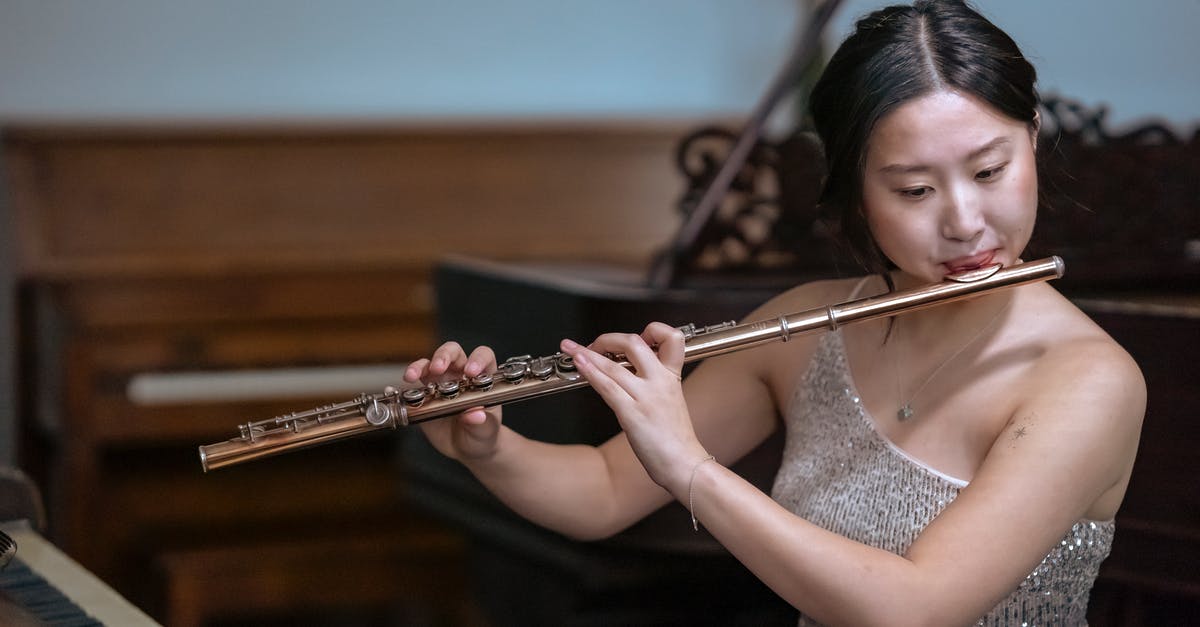 How do I make the player name show up on a /tellraw command? [duplicate] - Talented Asian female musician in elegant dress playing melody on flute while sitting near piano in modern studio on blurred background