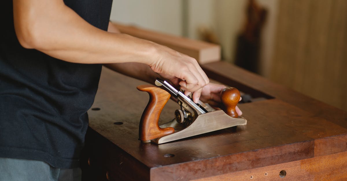 How do I manually change the resolution? - Side view of unrecognizable male carpenter changing knife in planer while cutting piece of board in studio on blurred background How do I manually change the resolution? - Side view of unrecognizable male carpenter changing knife in planer while cutting piece of board in studio on blurred background