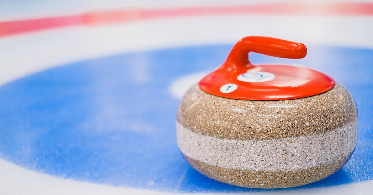 How do I maximize my speed at the beginning of a round? - Round curling stone with red handle placed on ice surface on ice rink in daytime