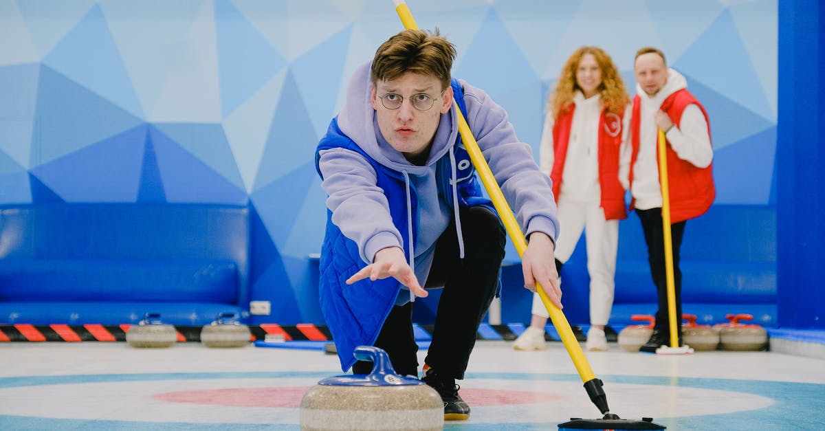 How do I move a rock? - Concentrate male in sportswear with broom in hand throwing granite curling stone sliding on ice sheet while playing game near team How do I move a rock? - Concentrate male in sportswear with broom in hand throwing granite curling stone sliding on ice sheet while playing game near team
