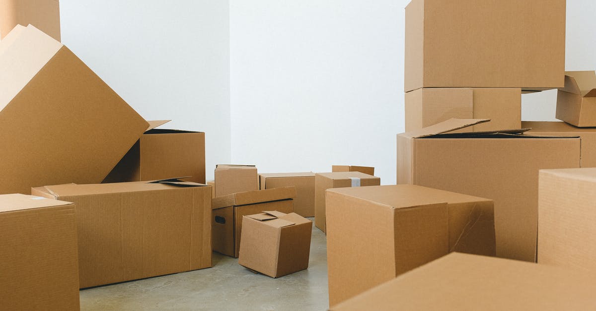 How do I move objects around freely? - Stack of carton boxes of various shapes and sizes scattered in floor near white walls during relocation