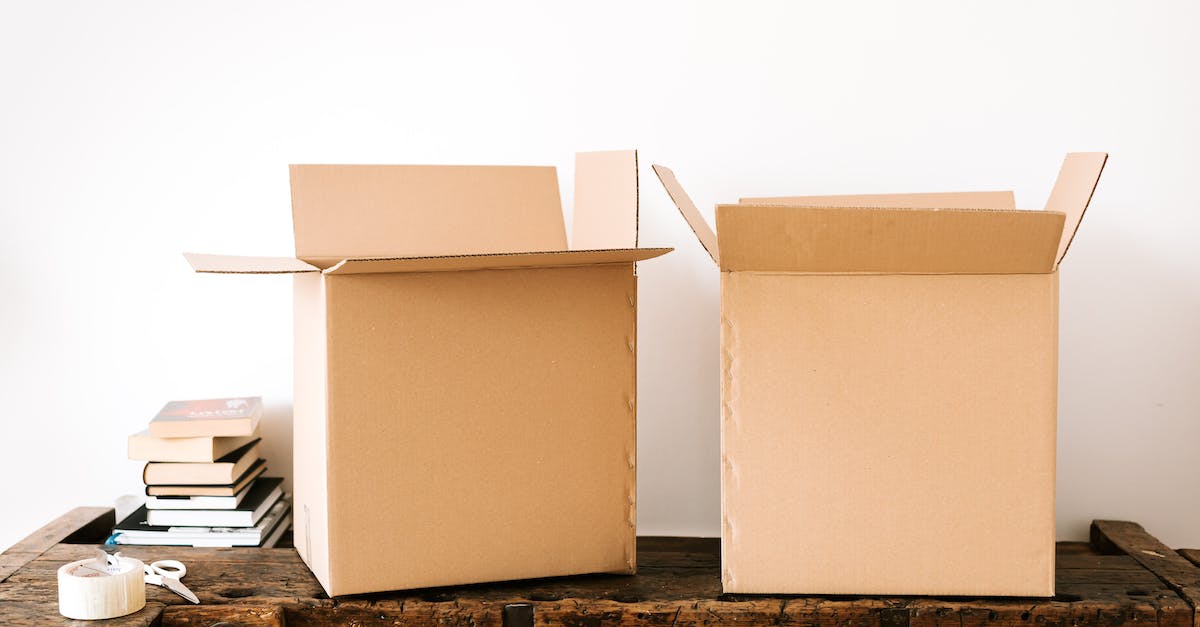 How do I open the Candy Box? - Opened carton boxes and stacked books placed on shabby wooden desk with tape against white wall How do I open the Candy Box? - Opened carton boxes and stacked books placed on shabby wooden desk with tape against white wall